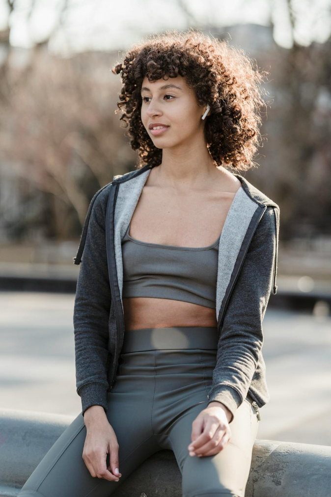 woman in matching gray yoga set resting on her run 