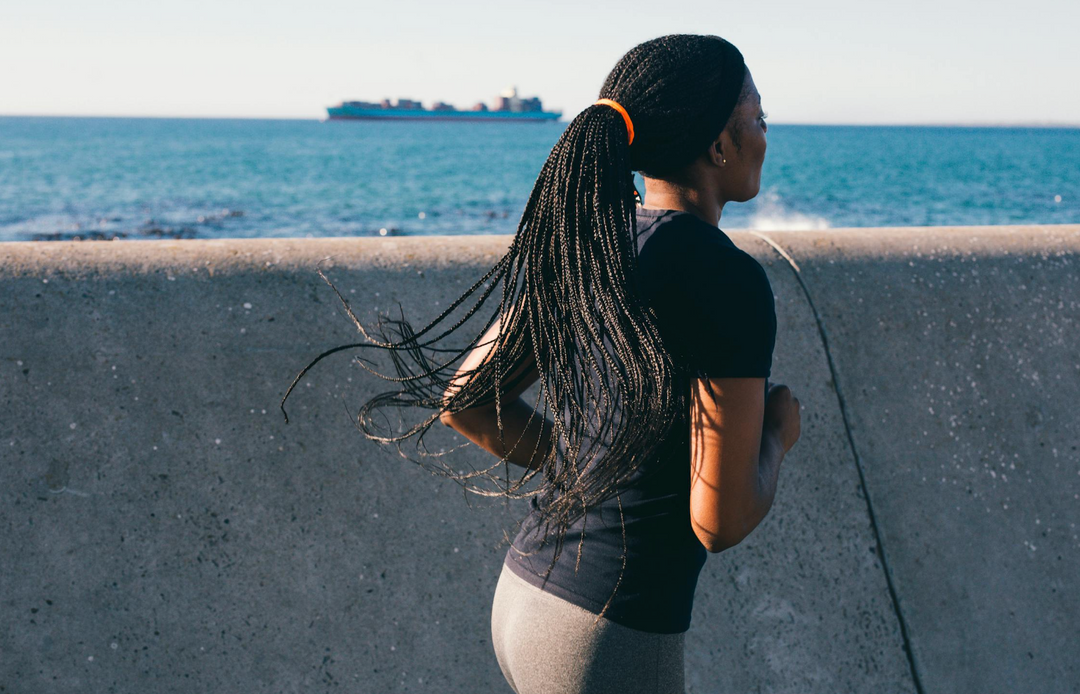 Woman running near a body of water 